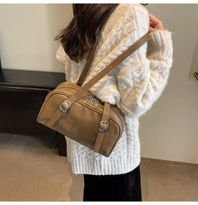 Détail du sac Boston vintage marron avec boucles en métal argenté et texture en cuir pur