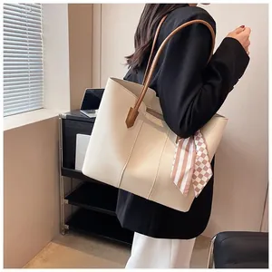Detail of cream tote bag with brown straps and silk scarf detail for office workers