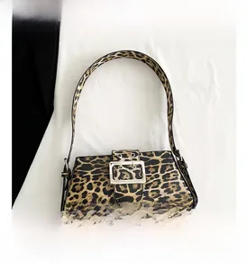 Close-up of leopard print shoulder bag featuring textured animal pattern and silver buckle