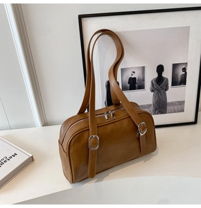 Détail du sac bandoulière marron caramel en simili cuir avec double fermeture éclair et boucles