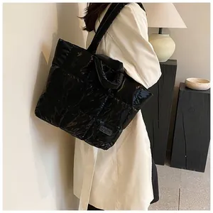 Close-up of black quilted tote bag with glossy finish and fashion tag detailing