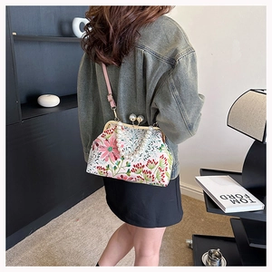 Detailansicht der Vintage-Blumenstickerei auf Kiss-Lock-Tasche mit Perlengriff und Riemen