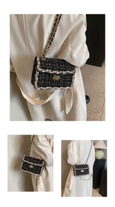 Détails macro du tissu tweed noir et blanc et de la bandoulière chaîne dorée du sac