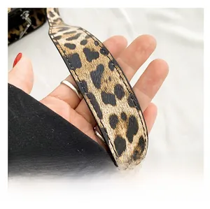 Detail of leopard print shoulder strap with reinforced stitching and silver metal buckle