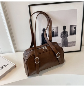 Détails du sac baguette vintage marron foncé montrant la texture cuir et boucles argentées