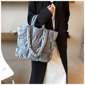 Close-up of metallic silver quilted tote bag with padded handles for stylish winter wear