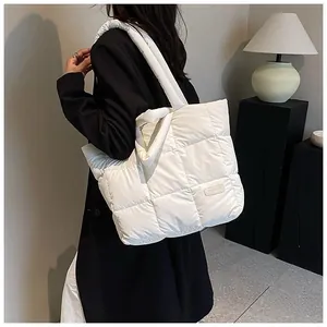Detail of white quilted tote bag featuring a round Fashion patch and down padding texture
