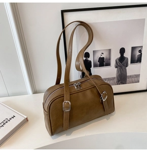 Détail du sac Boston vintage en cuir marron mat avec boucles argentées et double fermeture éclair