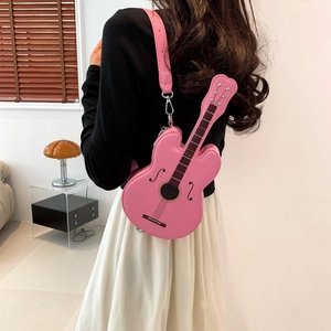 Fashionable pink guitar shaped crossbody bag shown on model with chic leather texture