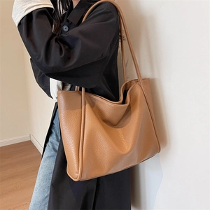 Large caramel faux leather tote bag with lychee texture shown on model for daily commute