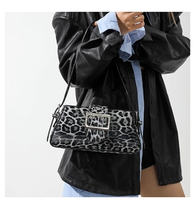 Close-up of leopard print shoulder bag with large silver metal buckle detail