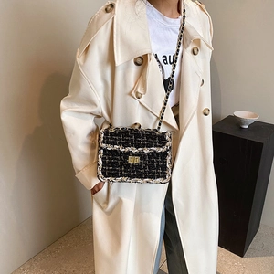 Sac bandoulière élégant en tweed noir et blanc avec fermoir doré et bandoulière en chaîne