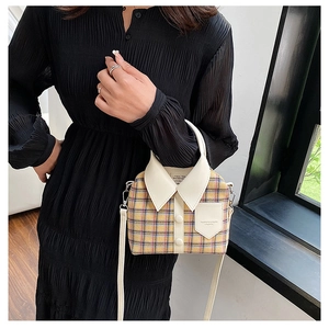 Detail van creatieve geruite crossbodytas in de vorm van een overhemd met witte bies