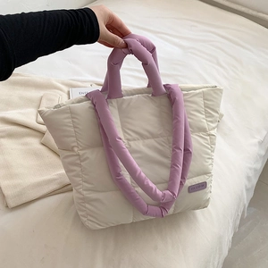 Quilted off-white puffer tote bag with purple handles and fashion label for winter