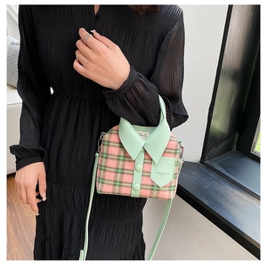 Detail van creatieve tas met overhemdkraag in roze en groen ruitpatroon met mint leer