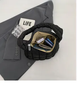 Detailed interior of black quilted puffer bag showing large capacity and pockets