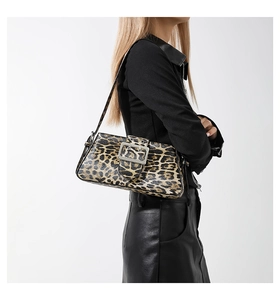 Close-up of leopard print baguette bag with a silver square metal buckle on a shoulder strap