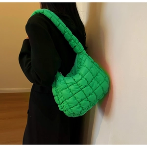 Detailed view of neon green quilted cloud bag with puffy texture and wide shoulder strap