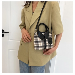 Detail of unique beige checkered handbag with black shirt collar design and top handle