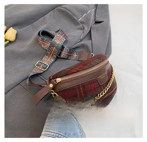 Détail d'un sac bandoulière en laine à carreaux avec chaîne dorée et large sangle