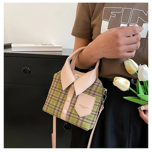 Detail of creative shirt-shaped plaid handbag with leather handle and button decoration