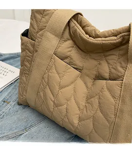 Macro view of khaki quilted down tote bag fabric texture with padded carry handles