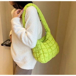 Detail of the bright green quilted puffer bag featuring a soft cloud texture and wide strap