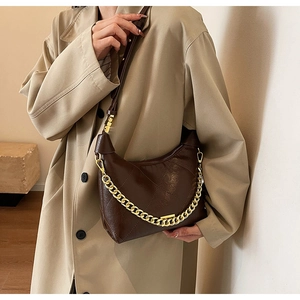 Vue détaillée d'un sac demi-lune marron foncé avec matelassage et chaîne dorée