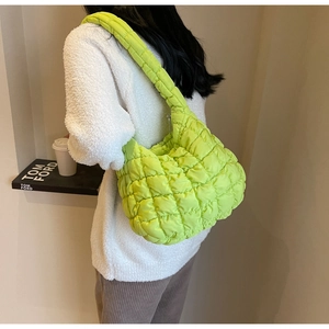 Detail of a bright green quilted cloud bag featuring lightweight nylon fabric and wide strap