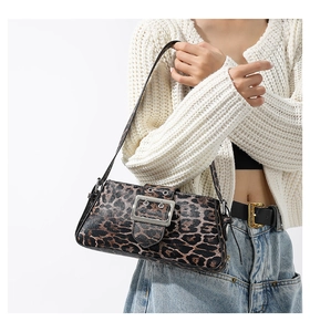 Detail of leopard print baguette bag featuring a large silver buckle and slim shoulder strap