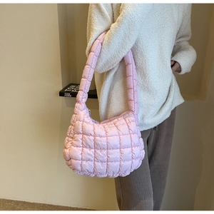 Macro view of pink quilted cloud bag with padded texture and silver zipper detail