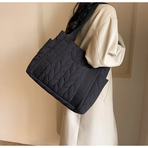 Close-up of leaf pattern quilted texture on black large capacity nylon tote bag