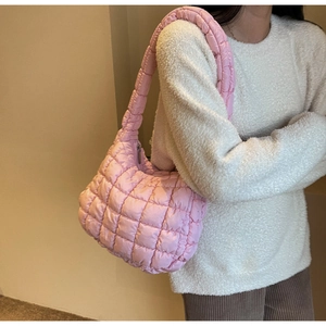 Close-up of pink quilted puffer shoulder bag with soft cloud texture and wide strap