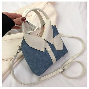 Detail van blauwe denim handtas in overhemdstijl met witte kraag, knopen en schouderriem