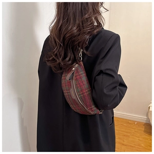 Gros plan du sac de poitrine en tweed à carreaux rouge et vert avec détails en cuir