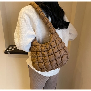 Brown quilted cloud shoulder bag with padded texture shown on model from behind