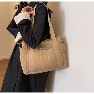 Detailed quilted leaf pattern and side pocket on a beige large nylon tote bag