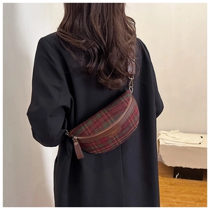 Gros plan d'un sac de poitrine à carreaux écossais rouge et vert porté par un modèle