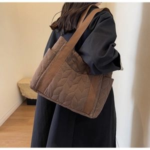 Detailed leaf-pattern quilting and canvas strap on brown padded nylon tote bag