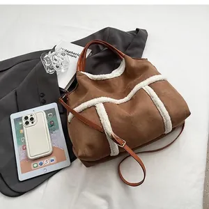 Size comparison between the brown suede tote bag and a smartphone for scale reference