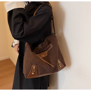Detail of vintage corduroy tote bag with leather patchwork and antique bronze studs