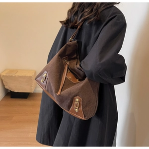 Detail of vintage corduroy tote bag with leather trim and gold buckle accents