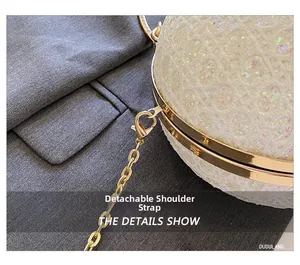 Detailansicht der abnehmbaren Goldkette an der Abendtasche aus weißer Spitze in Kugelform