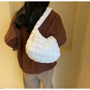 Detail of the white quilted cloud bag featuring soft puffy texture and crossbody strap