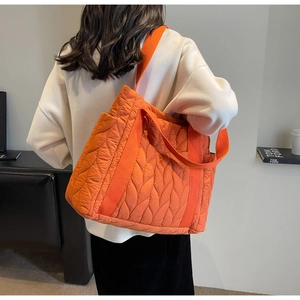 Detail of orange quilted tote bag featuring wave stitching and large capacity design