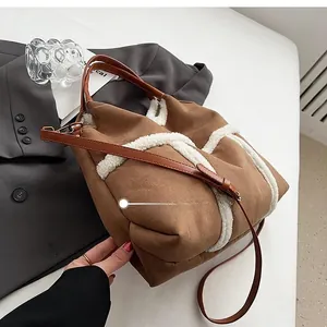 Brown suede tote bag detail with plush fleece trim and adjustable leather shoulder strap