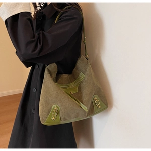 Detail of green corduroy tote bag with vintage rivets and textured leather stitching