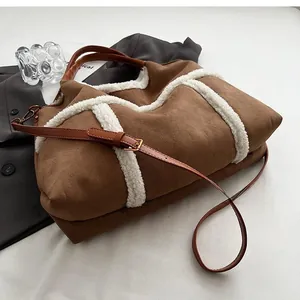 Close-up of the suede tote bag bottom showing brown leather base and white fleece trim
