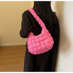 Detailed back view of a pink quilted hobo bag styled with a professional black blazer