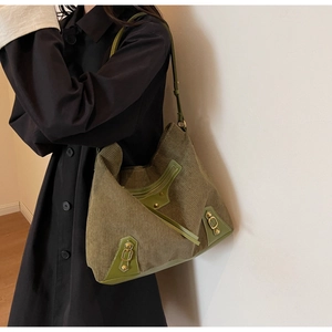Detailed view of dark green corduroy tote bag with vintage gold buckle and leather trim